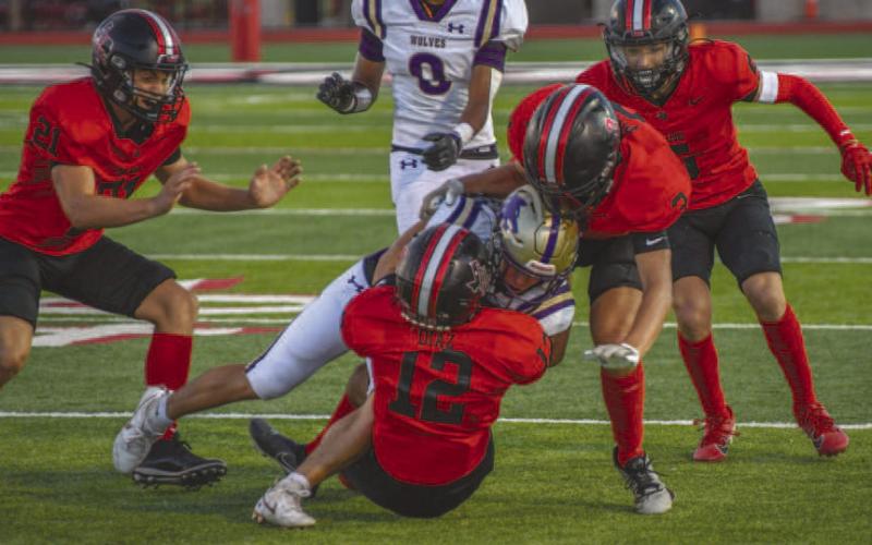 DOWN YOU GO - Levelland Lobos Josh Diaz and Gage Potter made the tackle on the Dalhart ballcarrier last Friday during the team’s season opener. (Staff photo by Dom Puente)