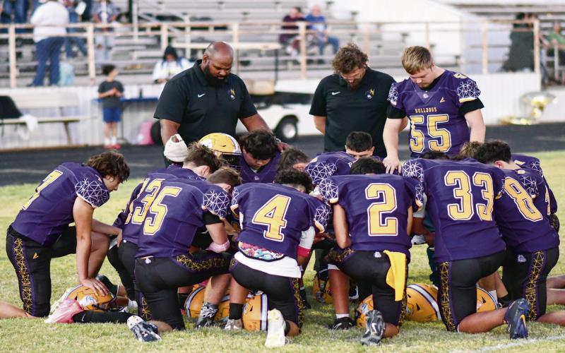 PREGAME PRAYER - The Anton Bulldogs varsity football team and coaches huddle together for a pregame prayer before their game against the Lazbuddie Longhorns this past Thursday night at Bulldog Stadium. Head Coach Brian Duncan would lead to Bulldogs to a 77-32 win as they would improve to 3-4 overall and 1-0 in district play this season. (Staff photo by Jentezen Smith)