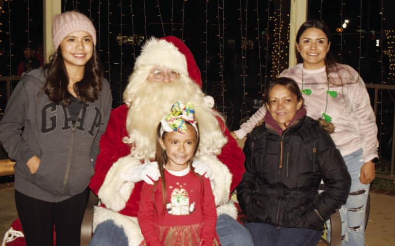 SMILES WITH SANTA - Darlene, Emily, Veronica and Erica Pina got to take a group photo with Santa Thursday during the Festival of Lights that was held in downtown Levelland. (Photo Courtesy of Delany Jackson)