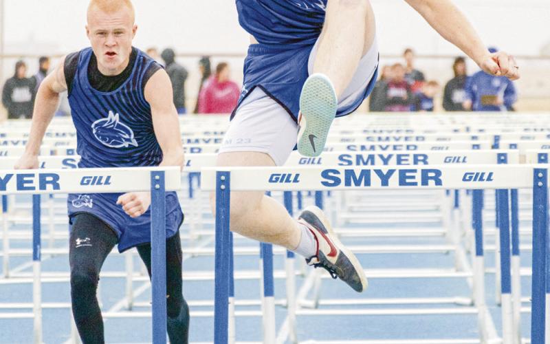 BOBCAT HURDLERS - Smyer’s Alex Mattox clears a hurdle while his teammate James Rampy prepares to do the same behind him this past Friday at the Bobcat Relays at Smyer High School. (Staff photo by Eric Venkatesan)