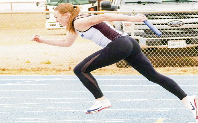 DRIVE OUT OF THE BLOCKS - Smyer Lady Cat Ellie Nelson drives out of the blocks with the baton in hand during a relay race this past Friday at the Bobcat Relays at Smyer High School. (Staff photo by Eric Venkatesan)
