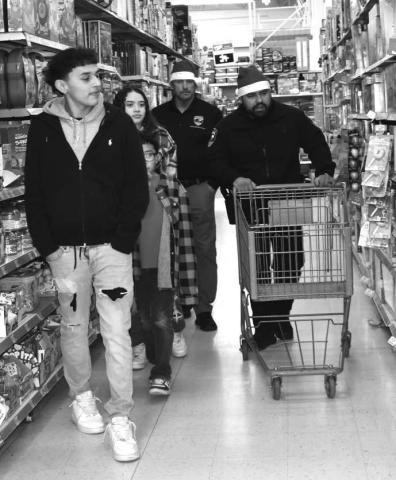TIME TO SHOP - Blue Santas were helping the children shop at Walmart during the third annual Blue Santa Event last Saturday. The Levelland Police Department where able to host 29 children and help them with there gifts they chose. (Staff photo By Emily Campos)
