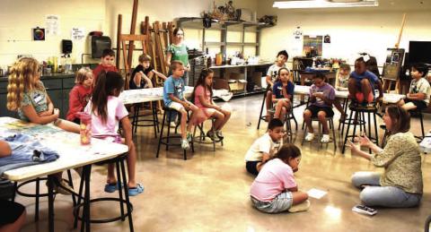 EXPLORE THE ARTS – Participants in the seven and eight-year-old class listening to Emily Wheeler explain how to use oil pastels. This art class was part of the Explore the Arts Camp at SPC last week. (Staff photo by Ada Niederhauser)