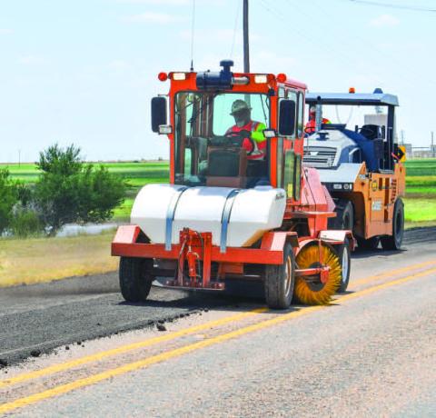 ROAD WORK - Hockley County TxDOT crews have been busy this past week as they have been working on county roads west of Levelland. Pictured are crews working on N. FM 2646, laying new asphalt along side the edges of the road. (Staff photo by Emily Campos)