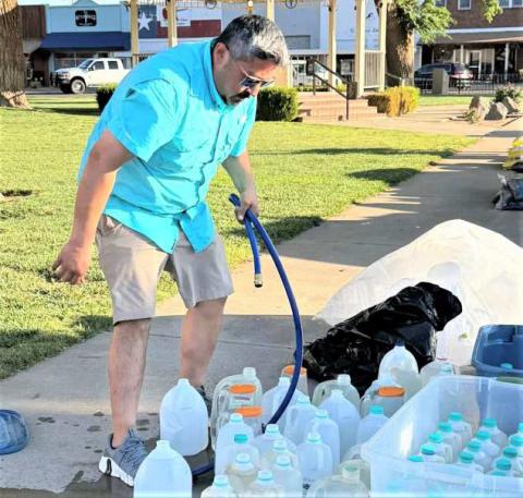 FILLING WATER JUGS- Community members worked this past Saturday, cleaning up and repotting plants around the Hockley County courthouse lawn. (City of Levelland Main Street photo)