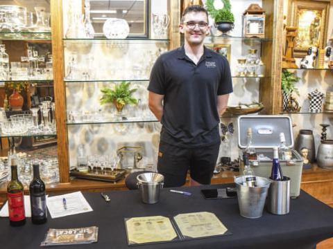 Stefan Ardeloff with English Newsroom smiled after serving guests wine in Atchinson’s Jewelry during Friday night’s Sip and Swirl event. (Staff photo by Evin Thomas)