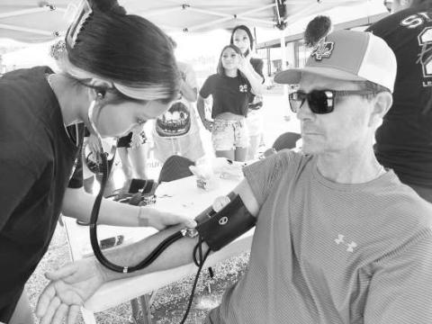 DIAGNOSIS - LHS Patient Care Tech students took advantage of the crowd last weekend at the Sweet HoCo Celebration to practice taking patient vital signs. Students are learning and relearning to be Patient Care Technicians in the class under the direction of Mrs. Joan Sanders. (Photo courtsey of Cristal Isaacks)