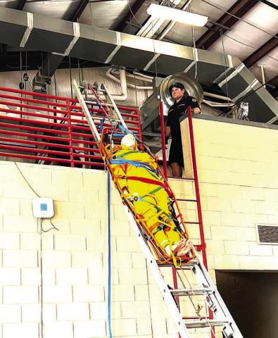 LADDER DRILLS - Levelland Fire Department practices moving a patient up or down a ladder on a stretcher, a procedure called a ladder slide, ladder pivot rescue, or hinge rescue. The patient is secured in a rigid basket stretcher rather than a standard wheeled gurney, and is raised or lowered using a specialized rope and pulley system. (LFD photo)