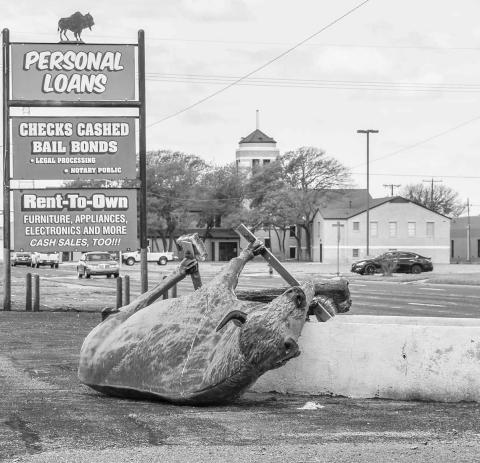 STRONG WINDS – Cleanup crews and volunteers have been working in shifts throughout the day since Wednesday to address the large swaths of debris scattered throughout the community. Pictured is the Personal Loans buffalo statue on Houston Street on its side due to the storms intense wind. (Staff photo by Dom Puente)