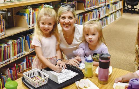 FAMILY FUN DRAWING- Pictured is Sharon Rice and grandaughters Racheal and Emma Rice who participated in the Hockley County Library Summer Program on Wedesday. The three enjoyed eating bagels and drawing what they wanted to be. Emma’s drawing showed that she wants to be a princess and Racheal’s drawing showed that she wants to be a Queen. (Photo courtesy of Emily Campos)