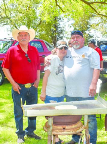 COOKING BRISKET - Grilling a brisket at the Jamaica in Morton was Oscar and wife Sonnya Alvarado and Enocencio Cruz . The booth was one of many sponsored by the St. Ann’s Caholic Church (Photo courtesy of Emily Campos)