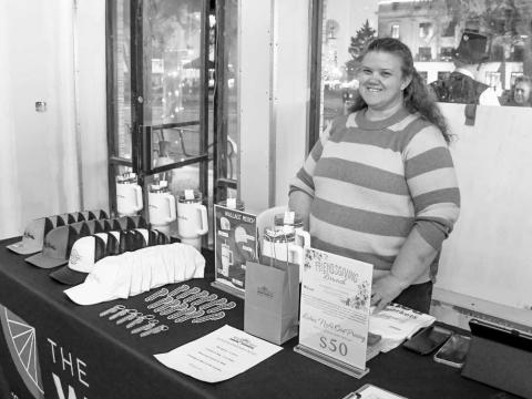 WALLACE STANDS – Tina Wiiest smiled at a Wallace Theater merchandise stand set up for attendees of Ladies Night Out in downtown Levelland on Thursday night. (Staff photo by Evin Thomas)