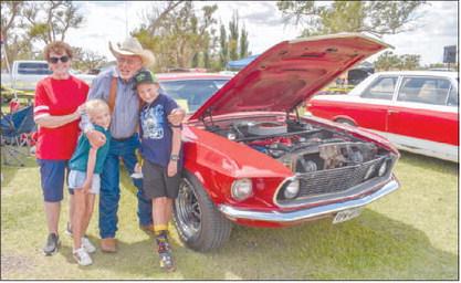 FUN WITH FAMILY – Pictured is Dan Patterson with his wife Joy Patterson and his grandkids Braelynn Patterson and Marshall Conklin. Patterson attended Levelland High School and has had his 1969 Ford Mustang since then. It has been through two tornadoes, light vandalism, and four teenage drivers from the same family all while retaining its original Candy Apple Red paint. The car won second place in the 1964- 1981 Ford Muscle Car Class at the Thunder on the Plains Car Show on Saturday at the Levelland City Par