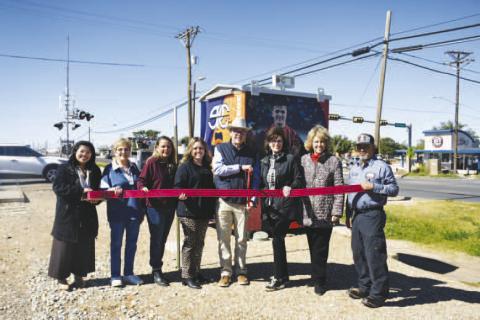 RIBBON CUTTING - A newly rewrapped bungalow can be seen at the corner of Sherman and HWY 114. Pictured left to right: Arra Delos Santos, Barbra Pinner, Angie Yandell. Adrian Mellberg, Dane Dewbre, Cristal Isaacks, Mary Siders and Freddy Ruiz. (Staff photo by Hannah Woodrum)