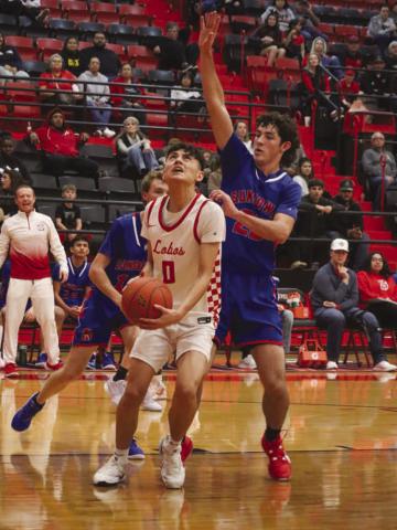 FOCUSED - Levelland Lobo Anthony Gonzalez was guarded closely by Sundown Roughneck Nathan McAdams under the basket during the team’s game last Friday night. (Staff photo by Aalijah Soliz)