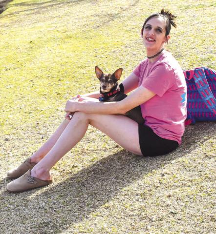 SPRING TIME - Nellie Burnett and her dog Bee used their Monday afternoon to soak up some sun light at Lobo Lake. Lobo Lake Park is made up of 11.5 acres and is located at Avenue H and 13th Street. The area includes a playground, picnic area, walking track, pavillian or amphitheater, fishing, a kayak launch and dock. (Staff photo by Emily Campos)