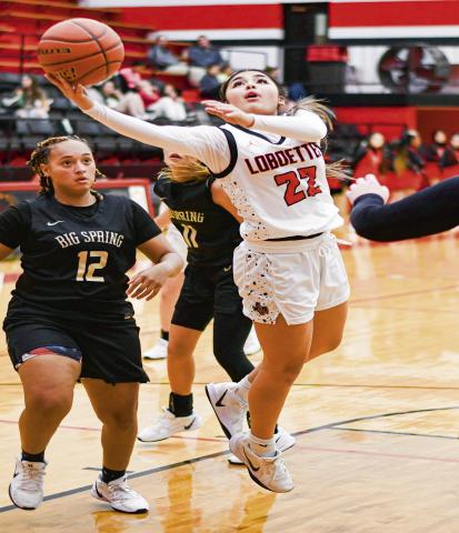 SPLIT THE DEFENSE - Levelland Loboette Jill Lopez splits three Big Spring defenders to put up a shot during their game this past Tuesday at Levelland High School. Lopez would score three points in the win. (Staff photo by Jentezen Smith)