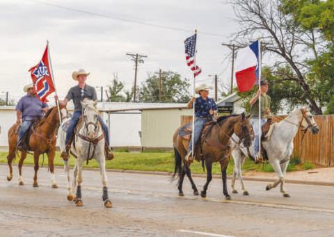 READY TO RIDE – Pictured are RD Motheral, Kye Powell, Bently Motheral, and Landry Farrar carrying the nations flag, state flag and Sundown flag at the beginning of the Oil Patch Days Parade on Saturday in Sundown. (Staff photo by Ada Niederhauser)