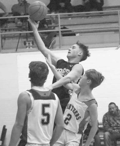 CONTESTED - Morton Indian Lane Lyon layed the ball up through the contact over Whitharral Panther Landon Lee to get the and one attempt last Tuesday. (Staff photo by Aalijah Soliz)