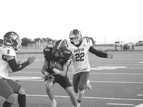 CHASEDOWN - Smyer Bobcat Peyton Casillas and Alex White made the tackle on the New Home player last Friday. (Staff photo by Aalijah Soliz)
