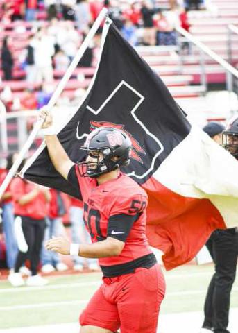 REPPIN’ THE LOBOS – Senior offensive and defensive lineman Deven Ponce proudly carries the Levelland Lobos flag as they take the field at Lobo Stadium for their football matchup against Pecos this past Friday night. The Lobos would go on to win 41-21. (Staff Photo by Jentezen Smith)