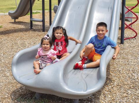 SUMMER FUN- Pictured are siblings Annalise Perez, Rosalyn Torres and Xavier Perez enjoying the cooler weather at the Levelland City Park on Tuesday. (Photo courtesy of Emily Campos)