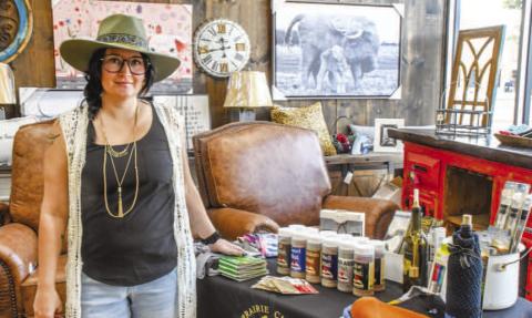 Keitha Lane stood with the Prairie Chick table inside Austin Street’s Our Stuff store, offering wine and food items to attendees of Friday night’s Sip and Swirl event. Prairie Chick was one of six wineries at the event. (Staff photo by Evin Thomas)