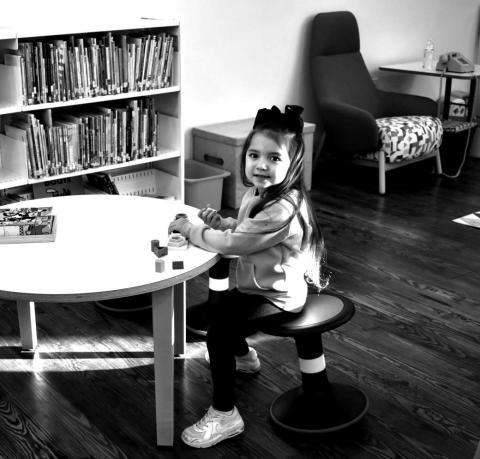 NEVER TO YOUNG TO LEARN- Little Koda Rodriguez could not wait for the New Sundown Library to Open. Here in photo she is siting at one of the new learning tables at the new library where the children can sit and read or play games.(Staff photo by Emily Campos)