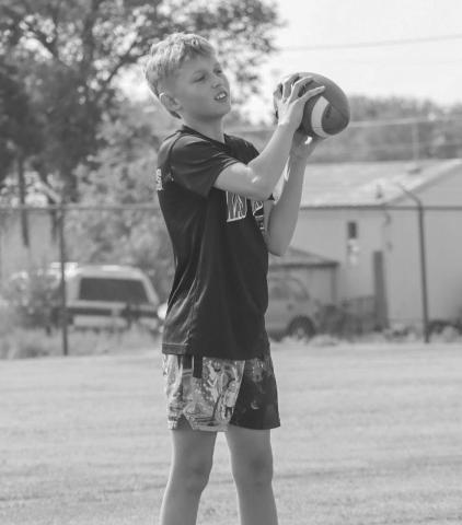 WARM-UPS - Last Thursday at the Morton Football Camp, student-athletes warmed up with throwing the ball to one another. Picutred above is a student catching a pass from another. (Staff photo by Aalijah Soliz)