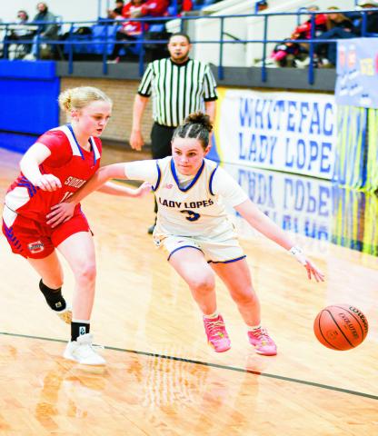 DRIBBLE DRIVE - Whiteface’s Kambry Sanders dribble drives past Sundown’s Kaytlin Clausen during their district game this past Tuesday night at Whiteface High School. (Staff photo by Jentezen Smith)
