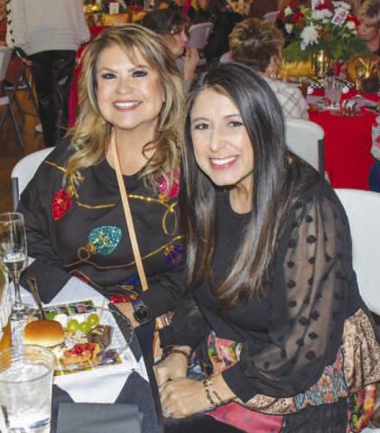 SNACKS – Chrissy Davila and Alexis Gavina smiled together with their plates of food during Levelland’s Fa La La event Dec. 12. (Staff photo by Evin Thomas)