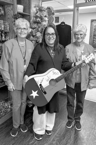 RAFFLE WINNER - Janie Mireles was recently announced as the Sugar Plum Gift Shop Raffle winner of a guitar signed by Kenny Maines. The proceeds from the raffle go toward scholarships or care givers. Additionally, other proceeds are for equipment for hospital needs. Pictured are Mireles with Kay McDaniel and Judy McMinn. (Submitted Photo)