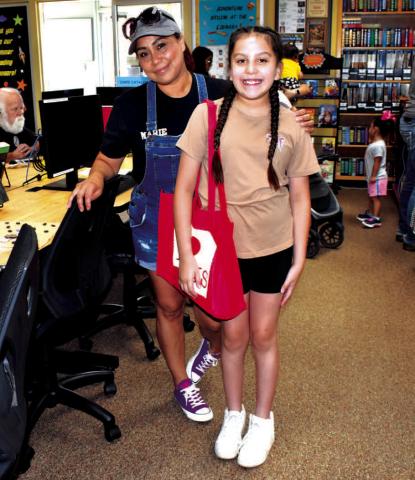 LIBRARY TIME- Amy Martinez participated in the Library Summer Program on Wednesday where she made a treasure map and checked out books at the Hockley County Memorial Library. Pictured is Maria Martinez and her daughter Amy Martinez spending quality time togeather.( Staff photo by Emily Campos)