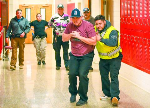 NECESSARY EVIL - Levelland Police Officers Blake Parker and Emilio Miranda demonstrated the proper technique for maneuvering through hallways and classrooms during an active shooter threat Tuesday afternoon at the Levelland Intermediate School. LPD Captain Mateo Lopez explained that the training has become a necessary evil as active threats in schools remain a possibility. (Staff photo by Dom Puente)