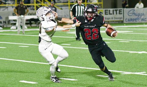 STIFF ARM BY JOHNSON - Whitharral senior running back Greg Johnson rushes the football and stiff arms a Sands defender during their playoff football game this past Friday night. Johnson would rush for 187 yards and three touchdowns in the loss. (Staff photo by Jentezen Smith)