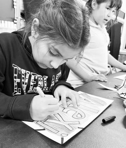 GRAFFITI ART-- Art teacher, Mrs. Mary Bara allowed third graders at South Elementary to trace their names using graffiti. The project introduced students to the origins of graffiti and helped students and teachers learn each other’s name for the upcoming year. Pictured is third grader Alexi Galindo. (Photo courtsey of Cristal Isaacks)