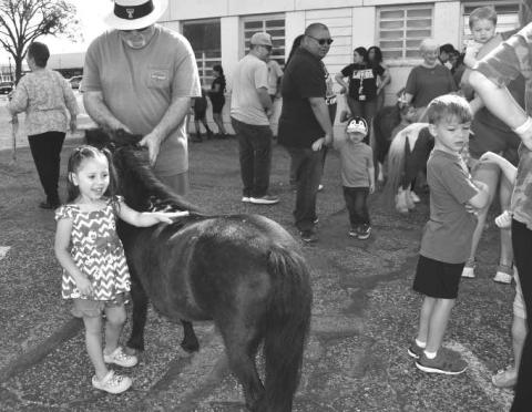 MINI HOOVES- Leyla Paez participated in the MINIS AND FRIENDSevent at t he Court House parking lot . Held by the Levelland Library summer program..Pictured is Leyla Pez and Paul Nolan. (Staff photo by Emily Campos)