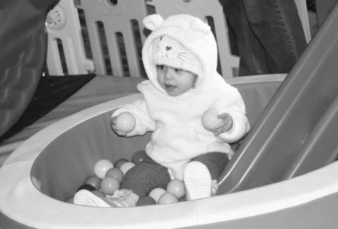 CUTENESS OVERLOAD- As the Event Festival of Lights begin with many activities on the square on Thursday evening little Victoria De La Cerna is caught playing in one of the bounce houses.(Staff photo by Emily Campos)
