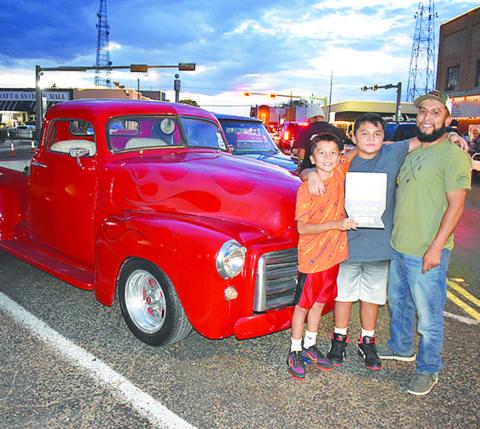 1953 CHOP TOP– Brandon Orosco and his sons, Jacob and Landon, all of Levelland, were having a blast cruising in their red flamed 1953 GMC Chop Top truck Friday night in the Thunder on the Plains Poker Run and Cruise. Orosco’s cousin painted the flames on the classic truck. The truck received a People’s Choice award in the cruise. (Staff Photo)