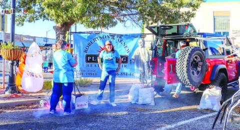 POPCORN TIME- Robertson &amp; Agnew Plumbing Heating &amp; Air handed out popcorn to the trick-or treaters at the Trunk or Treat on Halloween. Many families in the community attended the annual event. (Staff photo by Essence Childers)