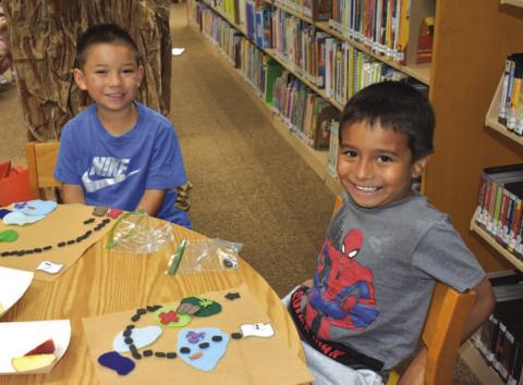 LIBRARY ART - The Hockley County Library had cut outs for the children that participated in the summer program so they could make a map of a treasure. Pictured is Eranza Alcantara and Xavier Perez. (Staff photo By Emily Campos)