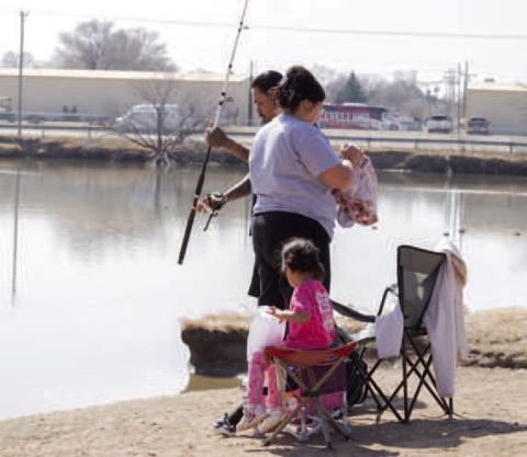 ENJOYING FISHING TIME— Pictured is a family takeing advantage of the warmer temperatures earlier this week by fising at Lobo Lake. Residents can enoy time outside at one of the many parks around town. (Staff photo by Eric Venkatesan)