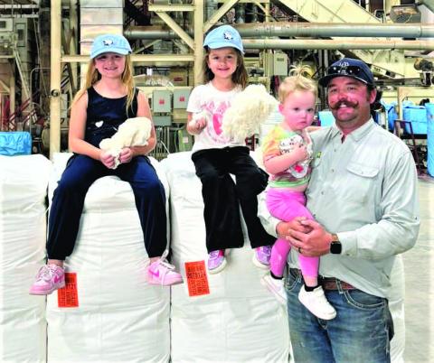Producer Derik Pearson, shown with his three daughters, Lottie, Darcy and Corinne, brought in the cotton bale of the season at United Cotton Growers Cooperative in Hockley County.