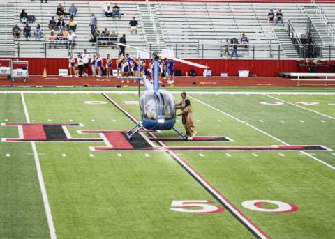GAME-BALL DELIVERY – The Levelland Football game ball is delivered to Head Coach Lyle Leong by helicopter as it lands in the middle of the football field at Lobo Stadium this past Friday night. The Lobos would go on to win 41-21. (Staff Photo by Jentezen Smith)