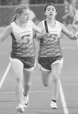 RELAY CHAMPS- The Sundown Roughette seventh and eighth grade track teams won district championships in track. The Roughneck seventh grade team placed fourth and the eighth team placed third. Roughette 200 relay runner Adelyn Franklin hands the baton to the anchor leg Kassady Rodgers. (Photo Courtesy of Sundown ISD)