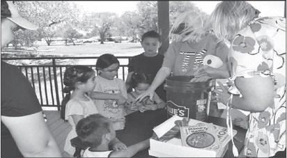 PLANTING - The Levelland Chamber of Commerce celebrated Earth Day with a few activities Tuesday afternoon at Lobo Lake. Kelly Hancock and Donna Wheeler helped children with planting seeds in small cups for them to take home and plant at their home.(Staff photo by Emily Campos)