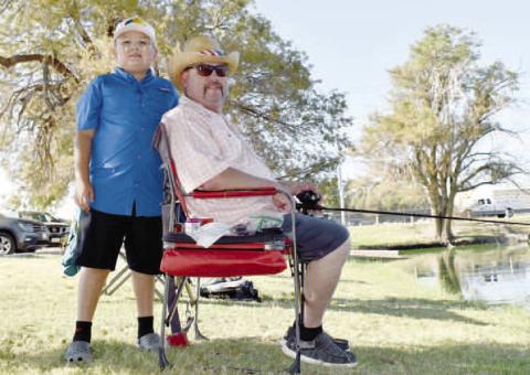 HAVING FUN OUTSIDE - Pictured are Nicholas Cruz and Jonny Cardona who were fishing together at Saturday’s Casting With Cops event at Lobo Lake. (Staff photo by Ada Niederhauser)