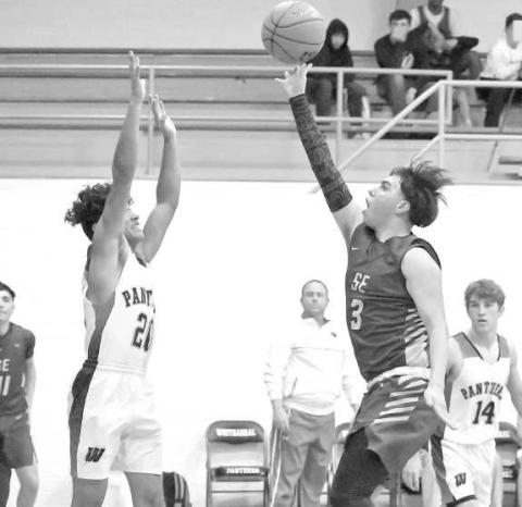 CONTESTING THE SHOT - Whitharral’s Nomar Gomez leaps up in the lane to contest a shot by Springlake-Earth senior, Micah Sanchez, during the first half of the Panther’s, 71-65, victory over the Wolverines in their Whitharral Tournament-Opener on Thursday. (Photo by Derek Lopez)