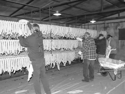 WORKINGINTHE SMOKEHOUSE - Pictured is Jerry Gonzalez, Vidal Hinojosa and Freddy Ruiz preparing the sausage in the smokehouse for the 40th Annaul Sausage Lovers Festival which will be held Sunday, Feb. 16 at St. Michael Catholic Church. (Staff photo by Adriana Solis)