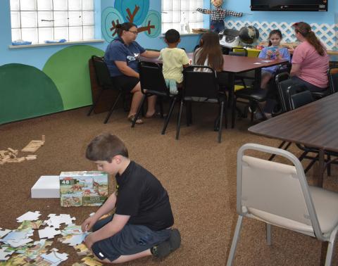 SOMETHING TO DO - Pictured are participants in the summer reading activ-ity at the library on Wednesday. They enjoyed many activities like board games, Jenga and puzzles. (Staff photo by Ada Niederhauser)